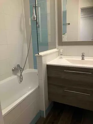 a bathroom with a sink and a tub and a sink and a mirror at 2 pièces avec piscine, 150 m de la plage. in Cannes