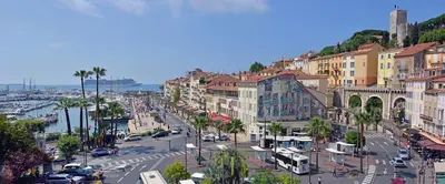 a city street with cars and buildings and a harbor at 2 pièces avec piscine, 150 m de la plage. in Cannes