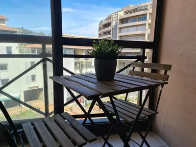 a wooden table with a potted plant on a balcony at BOCCA CABANA in Cannes