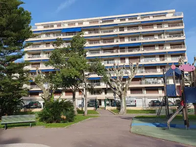 a large apartment building with a playground in front of it at Superbe vue mer à 50 mètres des plages in Cannes