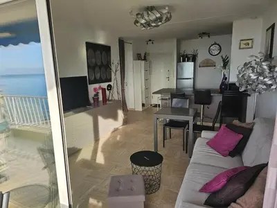 a living room with a couch and a dining room at Superbe vue mer à 50 mètres des plages in Cannes