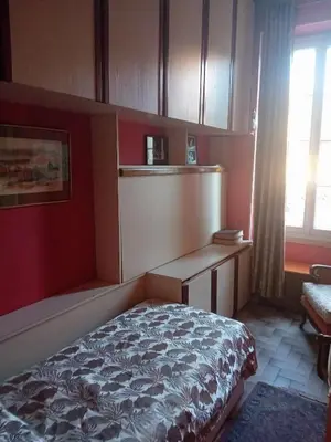 a bedroom with a bed and a desk and a window at Chambre d hôte artistique cannes in Cannes