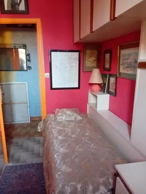 a bedroom with a bed in the corner of a room at Chambre d hôte artistique cannes in Cannes