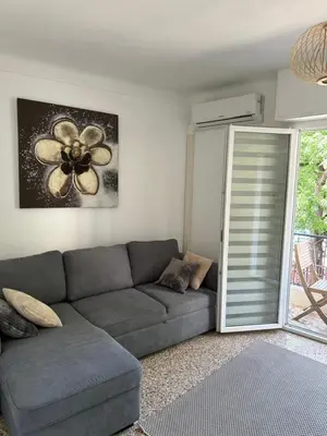 a living room with a couch and a flower painting at Appartement Cannes in Cannes