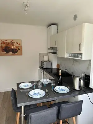 a kitchen with a table with plates and wine glasses at Appartement Cannes in Cannes