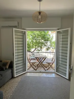 a living room with doors open to a patio with a table at Appartement Cannes in Cannes