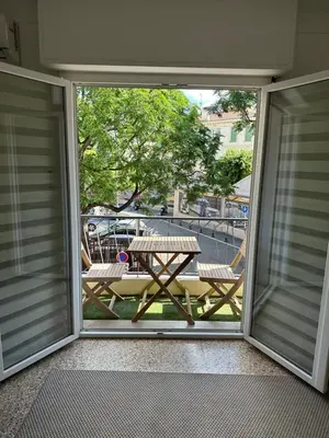an open sliding glass door with a picnic table on a patio at Appartement Cannes in Cannes