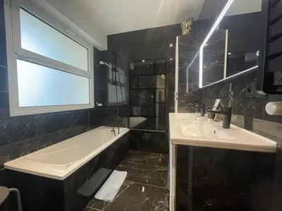 a bathroom with two sinks and a tub and a window at Cannes Cosy Oasis in Cannes