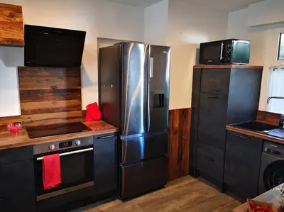 a kitchen with stainless steel appliances and black cabinets at Cannes Cosy Oasis in Cannes
