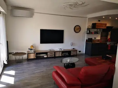a living room with a red couch and a flat screen tv at Cannes Cosy Oasis in Cannes