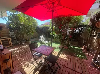 a table and a red umbrella on a patio at Cannes Cosy Oasis in Cannes