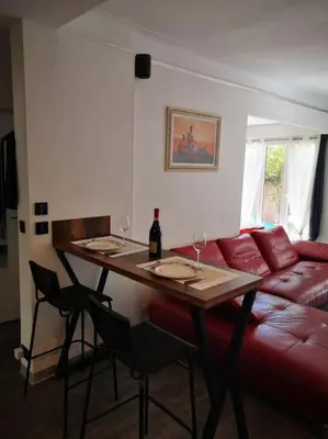 a living room with a table and a red couch at Cannes Cosy Oasis in Cannes
