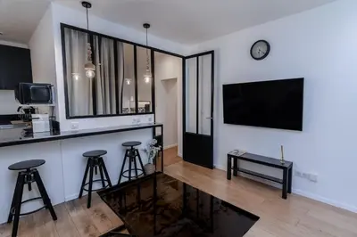 a living room with a bar and a tv and stools at Merveilleux appartement - Proche de la Croisette ! in Cannes