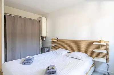 a bedroom with a large bed with towels on it at Comfort and serenity with A-C, Parking and Balcony in Cannes