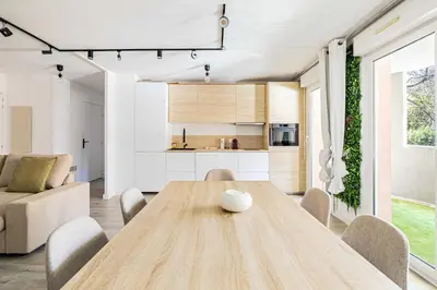 a kitchen and dining room with a wooden table and chairs at Comfort and serenity with A-C, Parking and Balcony in Cannes