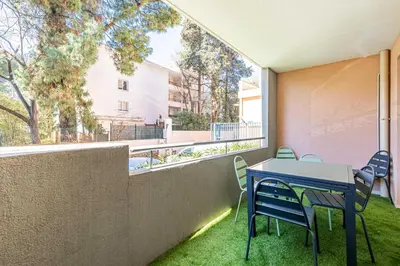 a patio with a table and chairs on a balcony at Comfort and serenity with A-C, Parking and Balcony in Cannes