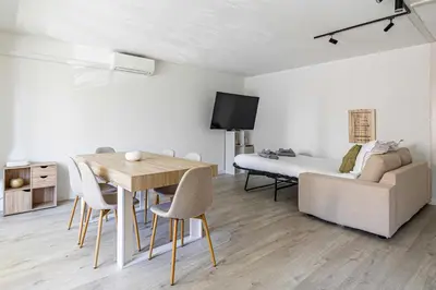 a bedroom with a bed and a table and chairs at Comfort and serenity with A-C, Parking and Balcony in Cannes
