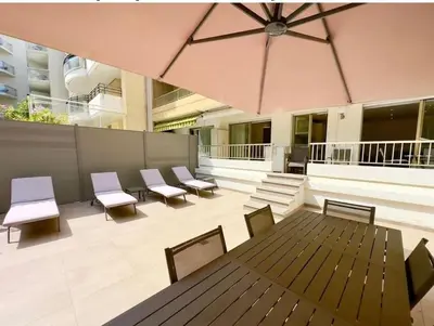 a patio with chairs and a table and an umbrella at Sweet home+terrasse de 60m2 ,2 mn from croisette beach in Cannes
