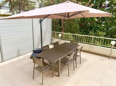 a table and chairs under an umbrella on a patio at Sweet home+terrasse de 60m2 ,2 mn from croisette beach in Cannes