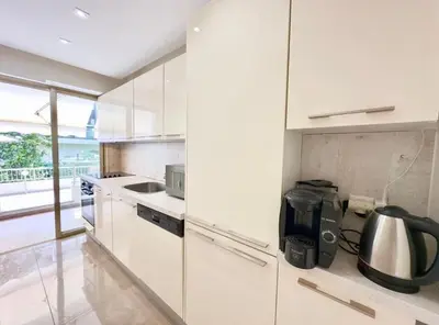a white kitchen with a sink and a stove at Sweet home+terrasse de 60m2 ,2 mn from croisette beach in Cannes