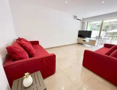 a living room with a red couch and a tv at Sweet home+terrasse de 60m2 ,2 mn from croisette beach in Cannes