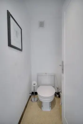 a bathroom with a toilet with a picture on the wall at Immogroom - cosy apartment - Terrace - AC - Wifi in Cannes