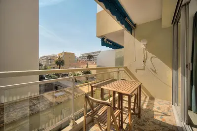 a wooden stool sitting on the balcony of a building at Immogroom - cosy apartment - Terrace - AC - Wifi in Cannes