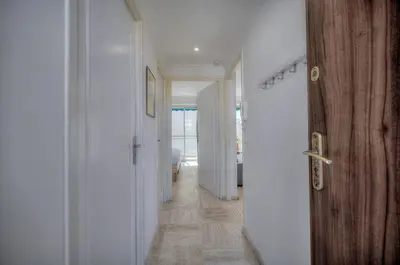 a hallway with white walls and a wooden door at Immogroom - cosy apartment - Terrace - AC - Wifi in Cannes