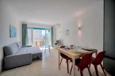 a living room with a table and a couch at Immogroom - cosy apartment - Terrace - AC - Wifi in Cannes