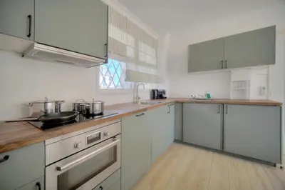 a kitchen with white cabinets and stainless steel appliances at Immogroom - cosy apartment - Terrace - AC - Wifi in Cannes