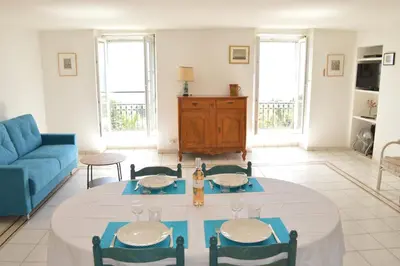 a room with a bed and a tv and a chair at Appartement vue mer proches plages et congrès in Cannes