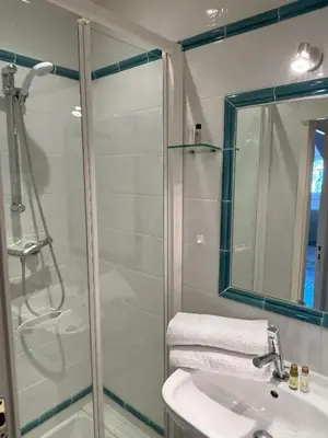 a small bedroom with a white bed and bookshelves at Appartement vue mer proches plages et congrès in Cannes