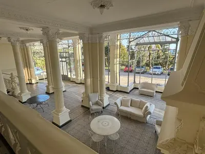 a lobby with columns and a couch and a table at Appartement vue mer proches plages et congrès in Cannes
