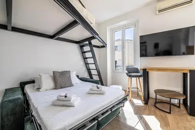 a bedroom with a loft bed with a ladder at 34 BORNIOL - Bel appartement rénové avec mezzanine Cannes in Cannes
