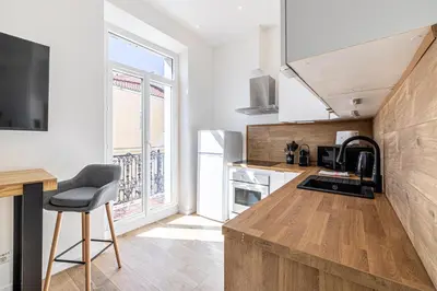a kitchen with a counter and a chair in a room at 34 BORNIOL - Bel appartement rénové avec mezzanine Cannes in Cannes