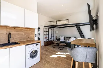 a kitchen and living room with a washer and dryer at 34 BORNIOL - Bel appartement rénové avec mezzanine Cannes in Cannes