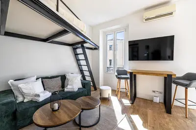 a living room with a green couch and a table at 34 BORNIOL - Bel appartement rénové avec mezzanine Cannes in Cannes