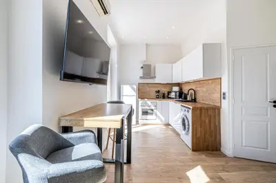 a kitchen with a table and a chair in a room at 34 BORNIOL - Bel appartement rénové avec mezzanine Cannes in Cannes