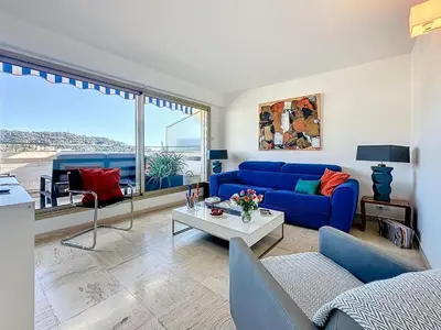 a living room with a blue couch and a table at Rooftop Grande terrasse Vue mer in Cannes