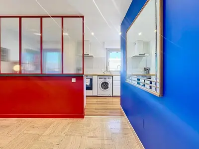 a kitchen with a red door and a blue wall at Rooftop Grande terrasse Vue mer in Cannes
