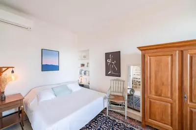a bedroom with a bed and a wooden cabinet at Cozystay 1669 Old Port View Elegant 3-Bedroom Apartment in Cannes