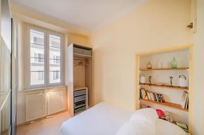 a small bedroom with a bed and a window at Cozystay 1669 Old Port View Elegant 3-Bedroom Apartment in Cannes
