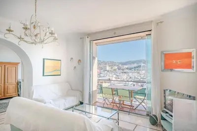 a living room with a white couch and a large window at Cozystay 1669 Old Port View Elegant 3-Bedroom Apartment in Cannes