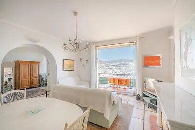 a living room with a bed and a large window at Cozystay 1669 Old Port View Elegant 3-Bedroom Apartment in Cannes