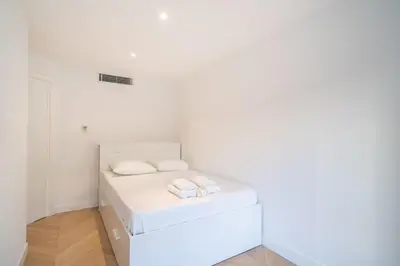 a white room with two beds in it at Magnificent 2 bedroom in the heart of Cannes in Cannes