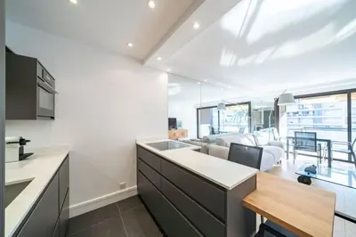 an open kitchen and living room with a couch at Magnificent 2 bedroom in the heart of Cannes in Cannes