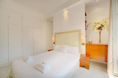 a bedroom with a white bed with two towels on it at Villa Luna Nova in Cannes