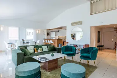 a living room with a green couch and blue chairs at RARE! 120m ROOFTOP 5-minute walk to downtown in Cannes