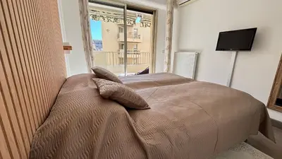 a living room with a black chair in a room at 2 Room modern, terrace and Parking in Cannes