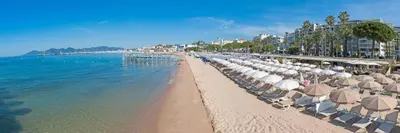 a beach with umbrellas and chairs and the ocean at Appartement Bord de Mer 4 pers / 2 Piscines in Cannes